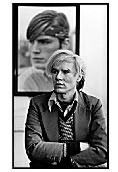 Andy Warhol at Desk with Joe Dallesandro Behind, Courtesy of Michael Childers